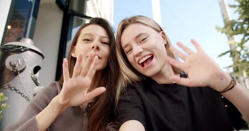 Young Women Smiling and Waving at Camera