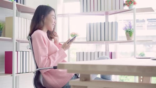 Smiling Woman Using Phone and Credit Card Indoors