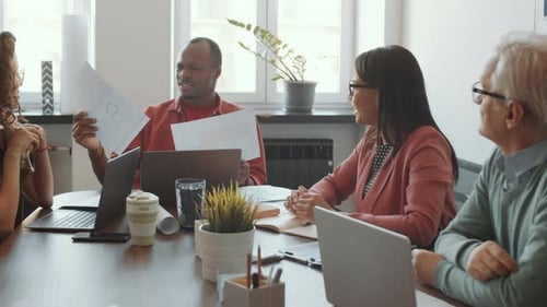 African American Manager Discussing Project with Team at Office Meeting