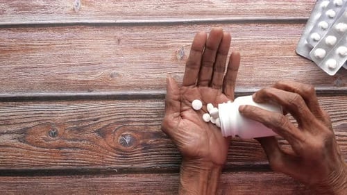 Senior Women Hand's Taking Medicine, Top View