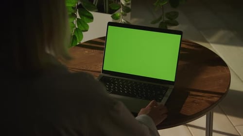 Handheld Shot of a Woman Watching Laptop Computer with Green Screen Chroma Key in Slow Motion