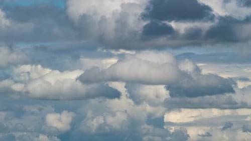 Zeitrafferaufnahmen von sich schnell bewegenden weißen, geschwollenen Cumuluswolken auf blauem, klarem Himmel