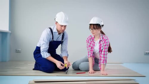 Couple Installing Laminate Wood Flooring in Home