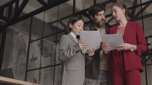 Team Discusses Business Documents in Modern Office