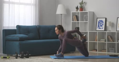 Athletic Woman Stretching at Home on Yoga Mat