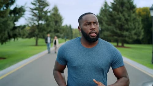 Athlete Doing Cardio Workout on Asphalt Road. Bearded Runner Training Outdoors
