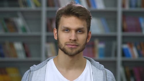 Smiling Young Adult in Front of Bookshelf