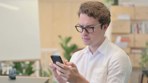 Young Adult Using Mobile Phone at Workplace