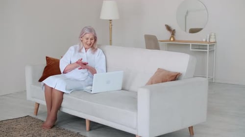 Senior Woman Video Chatting on Laptop at Home