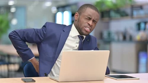 Tired African Businessman with Laptop Having Back Pain in Office