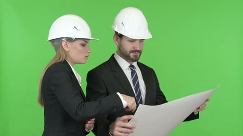 Zufriedene Ingenieure studieren Bauplan gegen Chroma Key