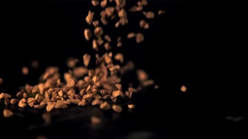 Instant Coffee Granules Pouring on Black Background