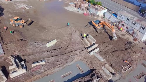 Aerial view of large construction site with several earthmover machines.