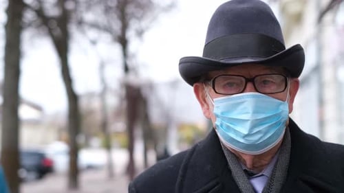 Senior Adult Wearing a Mask on City Street