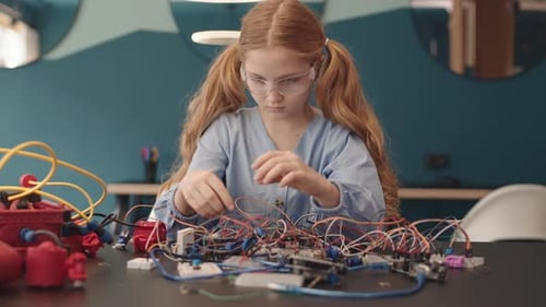 Child Inventor Connects Electronic Circuits at Table