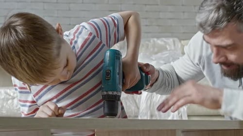 Father Teaching Son to Drive Screws into Furniture