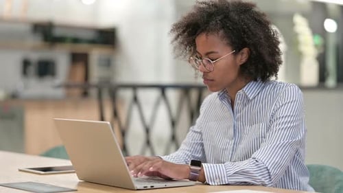 Focused African Businesswoman Working on Laptop in Office