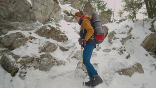 Woman Hiking on Steep Rocky Trail on Winter Day