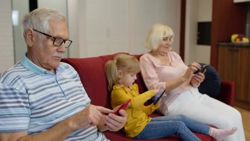 Family Using Mobile Devices on Couch Indoors