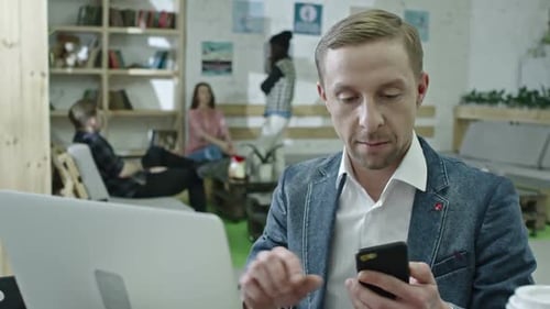 Stylish Office Worker Using Laptop and Talking on Phone