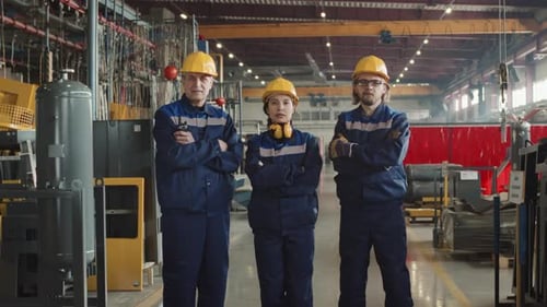 Factory Workers In Coveralls Posing For Camera