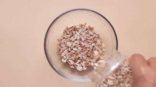 Flattened Rice Flakes Being Poured into Bowl