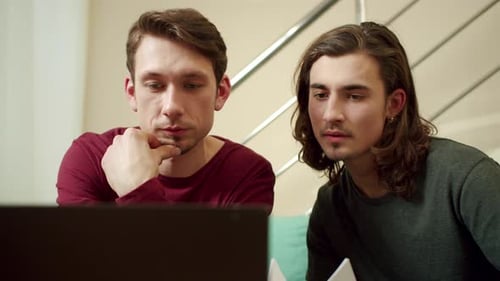 Two Friends are Working and Looking Something on the Laptop