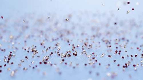 Falling Red and Gold Glitter Particles on Light Blue Background