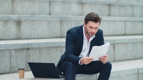 предприниматель читает документы и хмурится