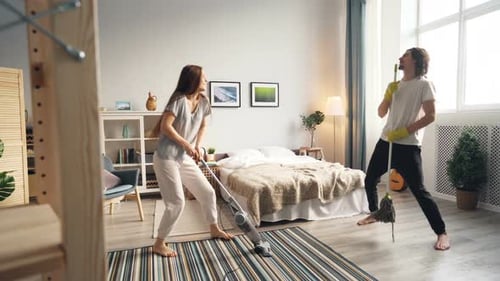 Happy Couple Cleaning and Dancing at Home