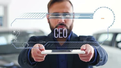 Un
homme d'affaires tient une tablette avec des éléments futuristes HUD. Hologramme avec inscription - CEO