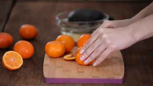 Slicing Tangerine on Wooden Cutting Board