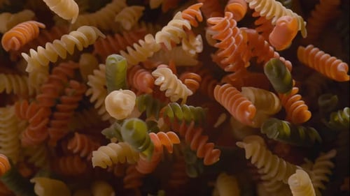 Les
pâtes rotini crues volent après avoir été explosées. Ralenti.