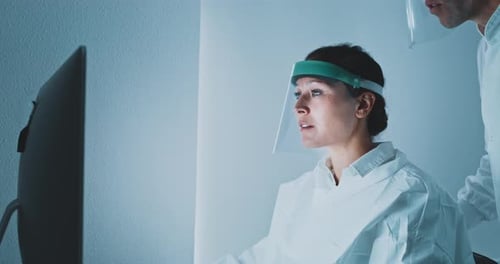 Scientists Working Together on Computer in Laboratory