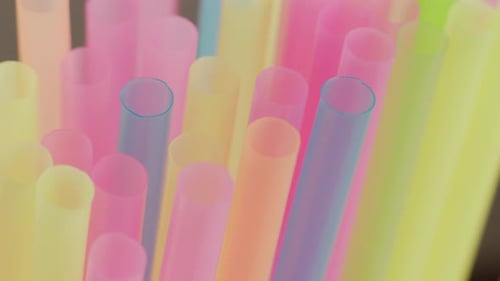 Plastic multicolored cocktail tubes, close up, camera movement, rack focus