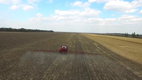 Traktor pflügt den Feldmais im Frühjahr, Luftaufnahme