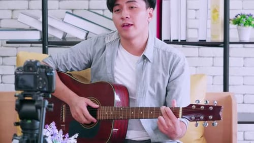 Man Plays Guitar and Sings for Camera