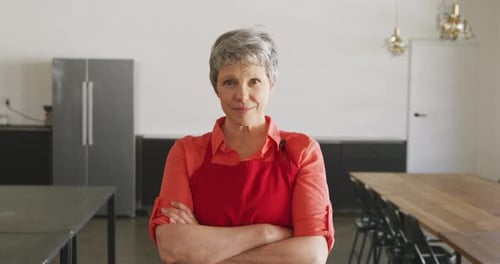 Smiling Woman with Crossed Arms in Kitchen