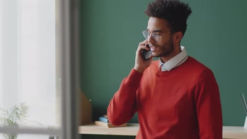 Young Adult Talking on Mobile Phone Indoors