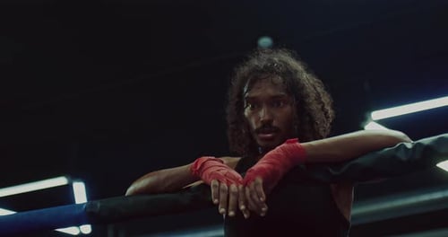 Intense Young Adult Boxer Resting in Ring