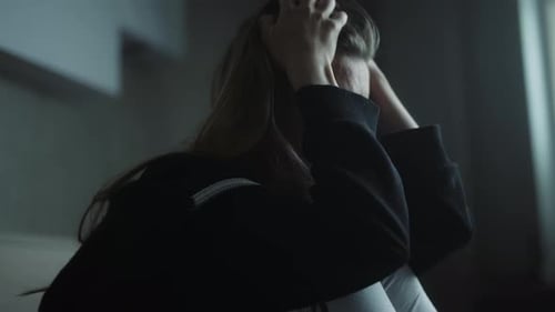 Distressed Woman Crying Indoors with Eyes Shut