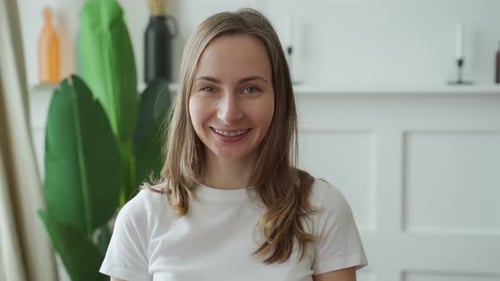 Smiling Woman Indoors with Green Plant