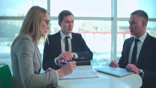 Business Meeting: Three Adults Discuss Strategy in Office