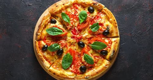 Close Up of a Pizza With Olives and Spinach