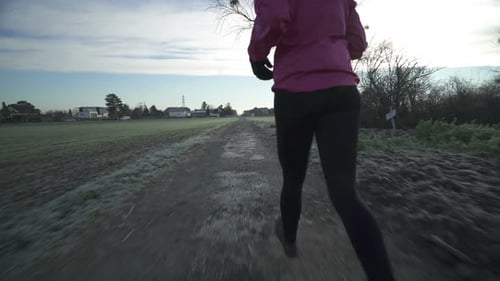 Woman Running on Dirt Track in Autumn