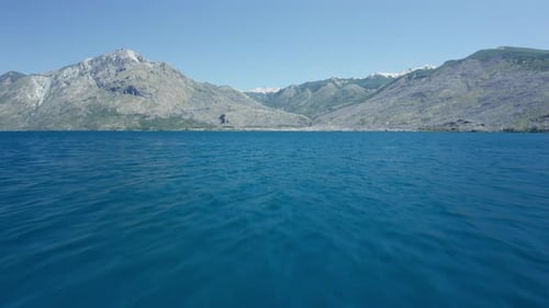 Drohne über das blaue Meer in Richtung Küste und Berge