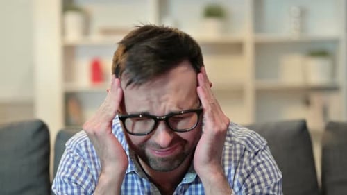 Man Massaging Temples Suffering from a Headache