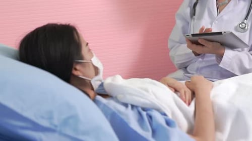 Doctor Wearing Face Mask Proficiently Talks with Patient at Hospital Ward