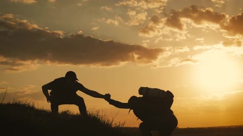 Silhouette of the Team on the Peak of Mountain