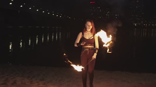 Woman Performs Fire Dance at Night on Beach